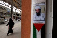 Photo of Al Qaeda founder and former leader, Osama Bin Laden, above a Palestinian Authority flag.